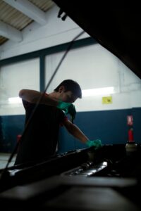 Mecanico revisando el nivel y estado del aceite del motor con la varilla medidora